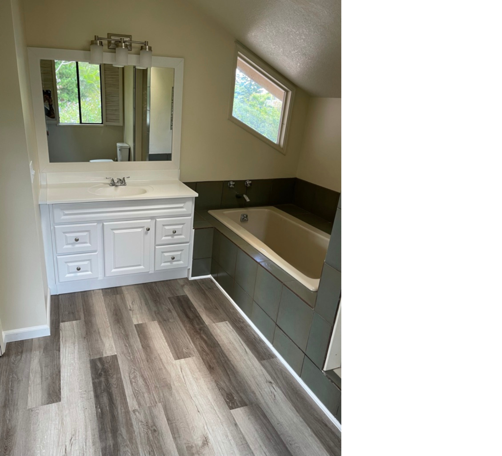 Earthy Elegance: Beige Wood Tones, White Tub & Bold Black Tile Accents Create a Stylish, Serene Bathroom