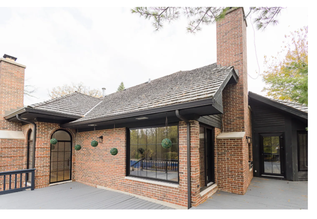 Brick Elegance: Home with Expansive Windows & Pool View